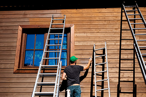 Holzschutz beim Streichen einer Holzfassade
